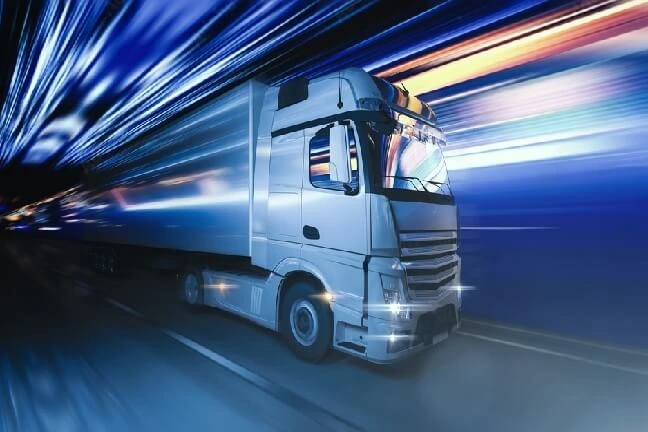 Abstraktní foto kamionu jedoucího po silnici s abstraktním pozadím. Modré pozadí. kamionová doprava